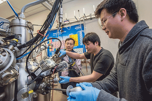 Berkeley Lab scientists Junqiao Wu, Fan Yang, and Changhyun Ko (l-r) are working at the nano-Auger electron spectroscopy instrument at the Molecular Foundry, a DOE Office of Science User Facility. They used the instrument to determine the amount of tungsten in the tungsten-vanadium dioxide (WVO2) nanobeams. (Credit: Marilyn Chung/Berkeley Lab)