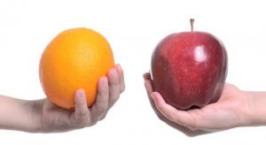 hands holding an apple and an orange