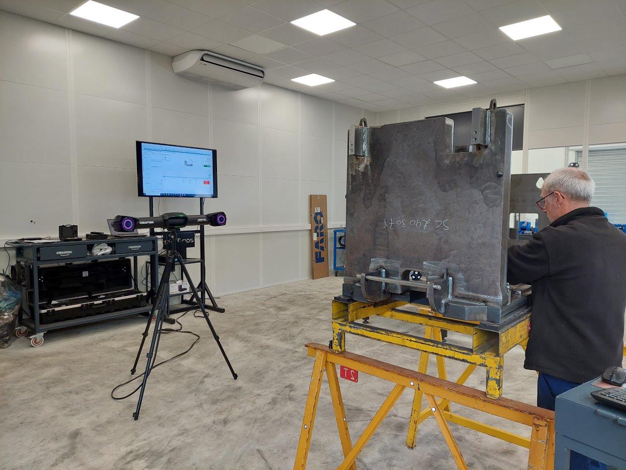 Employee using the Go!SCAN SPARK to scan a round casted part on a wood pallet